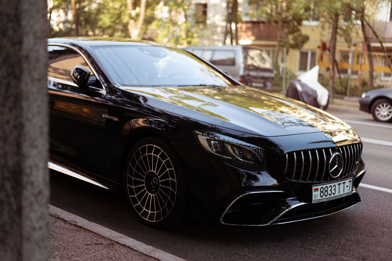 Luxury black car parked on an urban street, displaying elegance and sophistication.